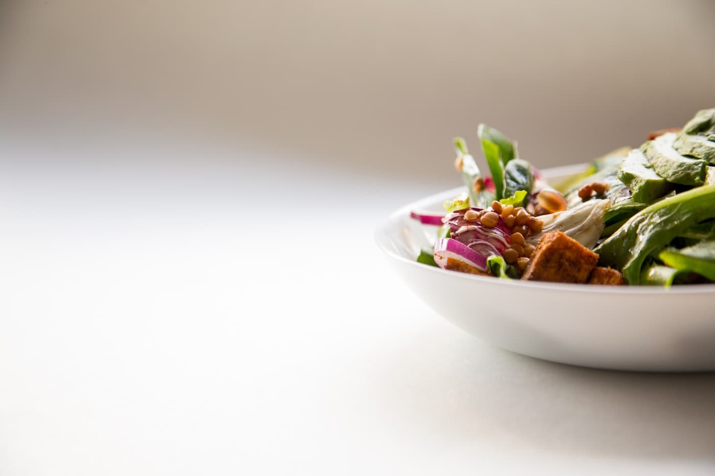Bol de ensalada fresca y saludable sobre fondo claro